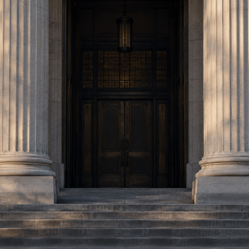 Stone courthouse columns framing a shadowed entrance.